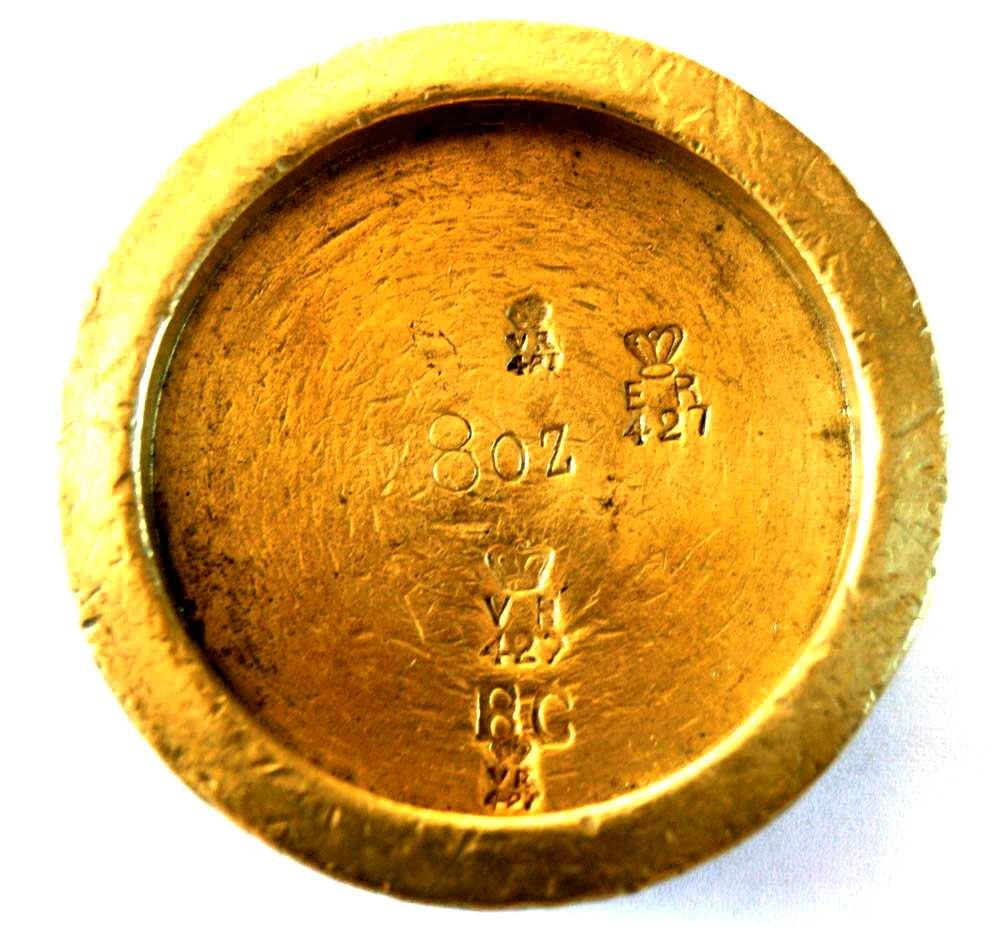 An 8oz brass weight with Cambridge Borough marks, including the letters BC several VR 427 marks, and an ER 427 mark.