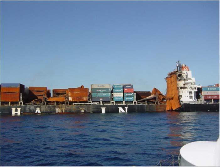 The M/V HANJIN PENNSYLVANIA (port) riding very low in the water as a result of fire fighting efforts.