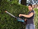 cutting a hedge. Pivoting blade is ideal for cutting the side of the hedge.