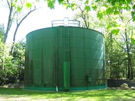 The steel tank is open on top with a wooden structure that both surrounds the tank and goes over the top.