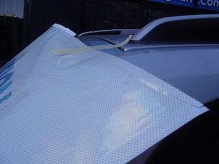 Secure the OWV film onto the vehicle with application tape. 6. Peel one half of the backing release liner from the OWV film.