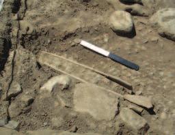 worked obsidian, groundstone tools, marine shells, iron slag, mold-made lead rivets, and fragments of bronze and glass found in this trench.