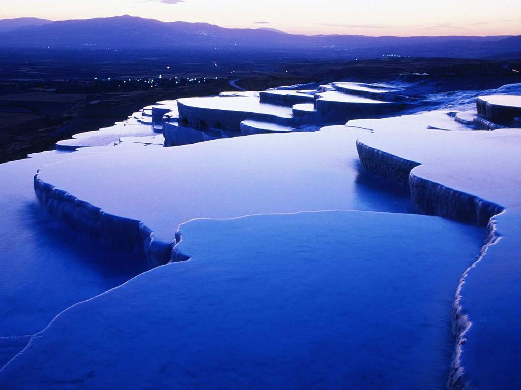 The city contains hot springs and travertines, terraces of carbonate minerals left by