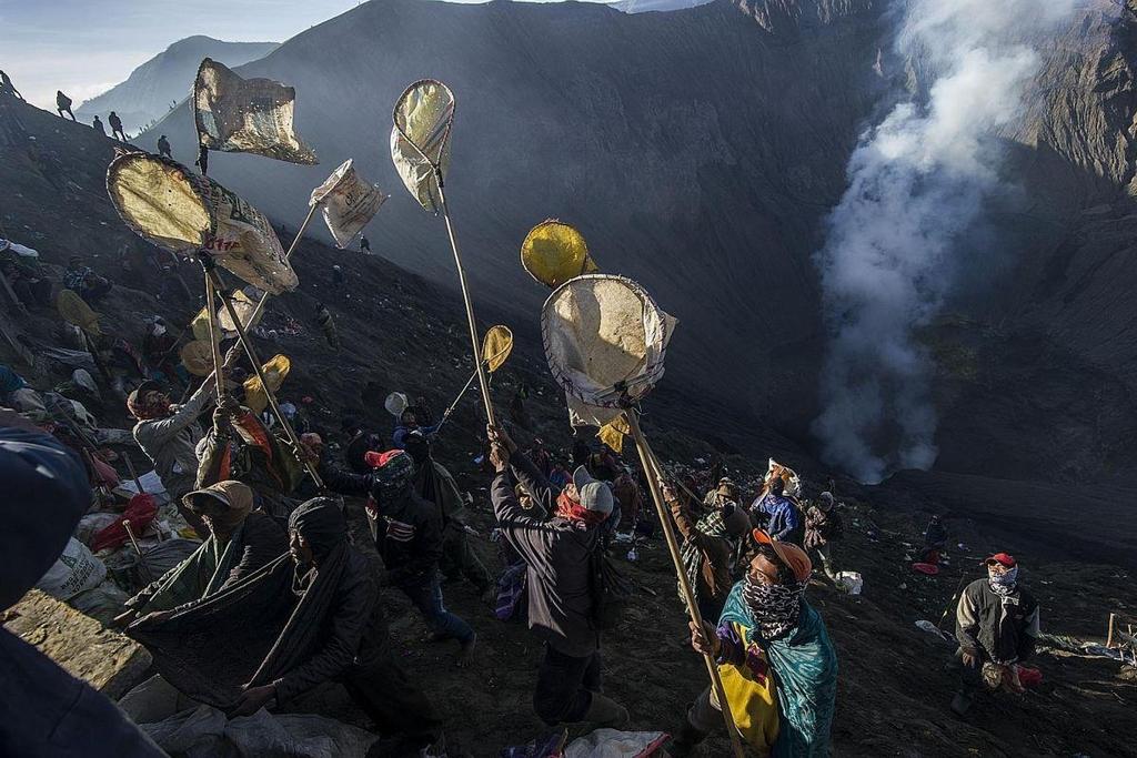 Villagers catching offerings with nets at Mount Bromo during the Yadnya Kasada