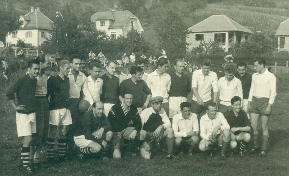 Slika 12: Laščani v belih dresih, fotografirani skupaj z neznanimi nasprotniki na domačem igrišču. Zadaj pa prve novogradnje po drugi svetovni vojni (arhiv Jožica Penič).