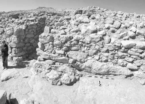 7. EB II city-wall W.103 made of huge limestone blocks and boulders, carefully set into the bed-rock with a battering foot, from north. 8. EB II city-gate L.160 of Khirbat al-batråwπ, from north.