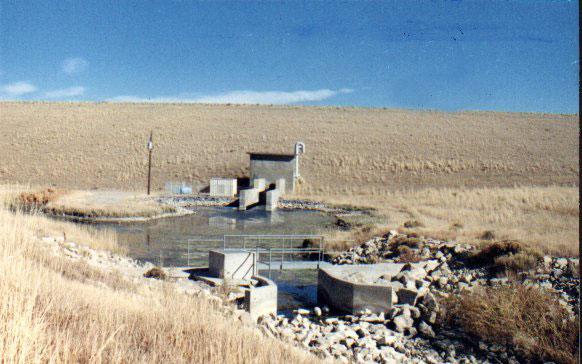98 Dam Construction Type: Earth-fill with rock face Outlet: 48-inch diameter steel outlet pipe through the dam that splits into 4 outlet pipes at the downstream control house.