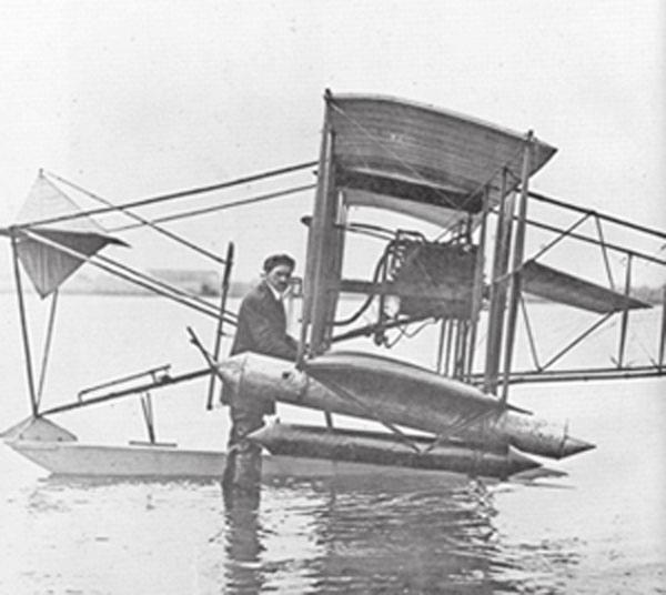 (Left) Glenn Curtiss stands in ankle-deep water. Spuds straps on the A-1. (Above) the A-1 flies over a Japanese sailing ship in San Diego Bay. to be attached to an army corps for actual war service.