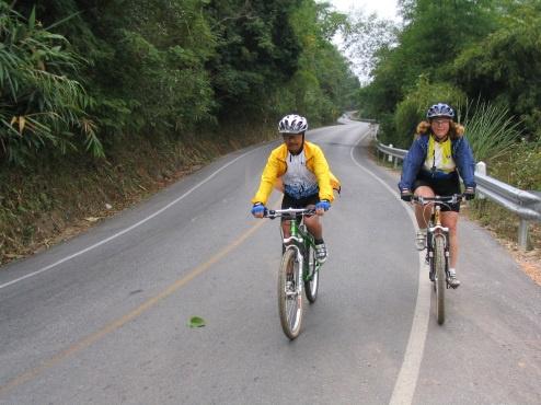 We can either take a tough dirt path or hilly paved road there, either way the ride is a good work-out. You ll pass jungle-covered mountains, lush fields and smiling locals all the way.