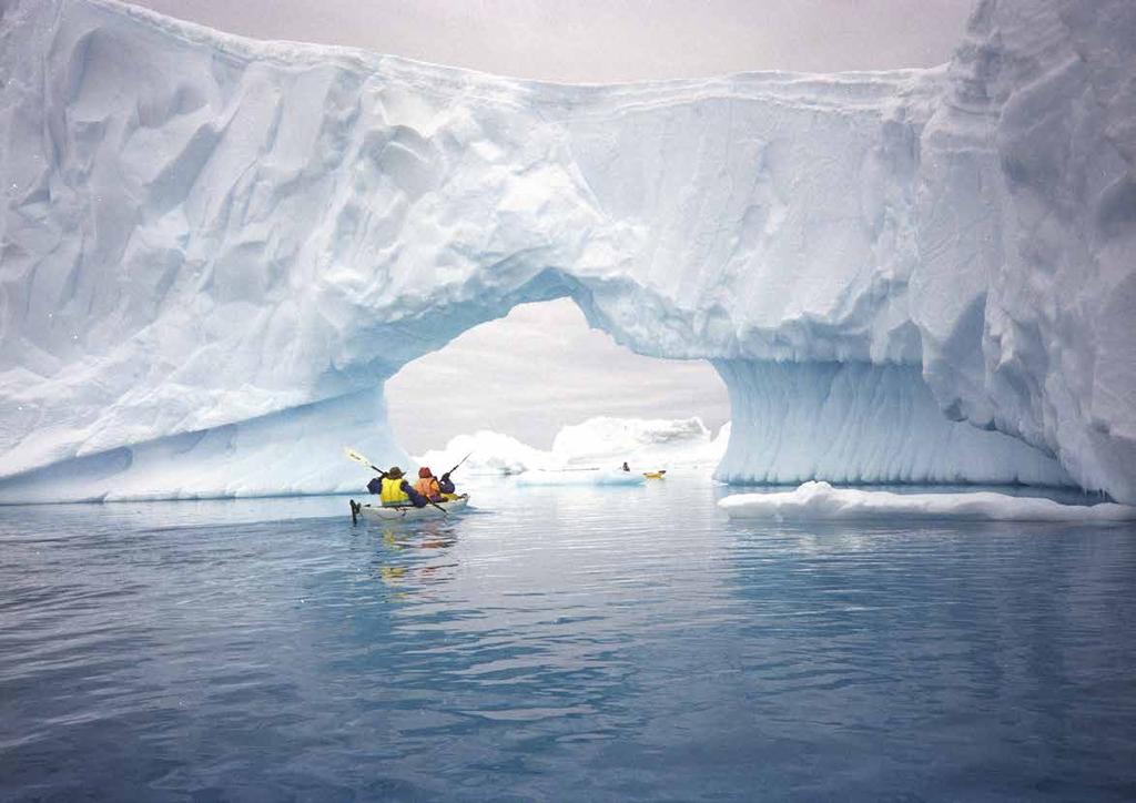 Eyal Kaplan, 2010. Antarctic kayakers paddling under a natural iceberg arch, Antarctic Peninsula.