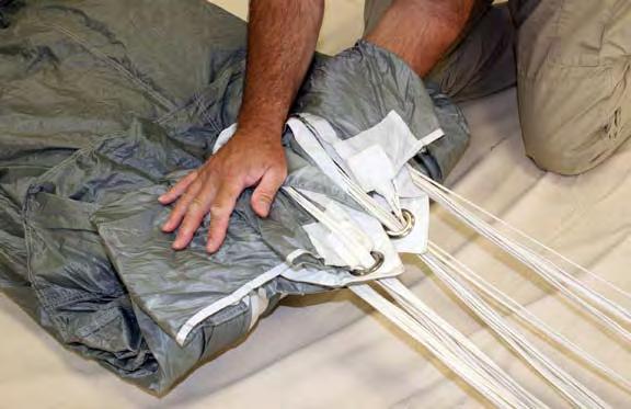 Place the opposite hand on the parachute approximately 15 up from the lower edge. Fold the stabilizers and slider toward the top of the parachute.