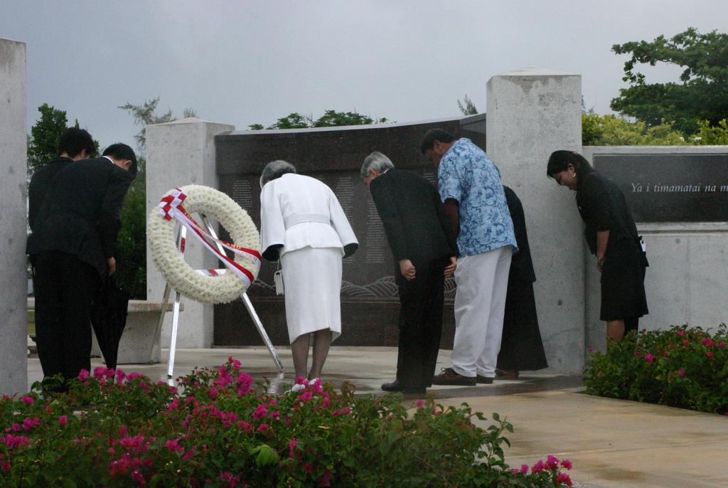 The Emperor and Empress of Japan bow in front of the wreath they laid at the Marianas Memorial at American Memorial Park.