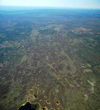 A high-altitude view of the Horn Plateau HS Ecoregion shows light brown burned peat plateaus with golden-brown collapse scars in the
