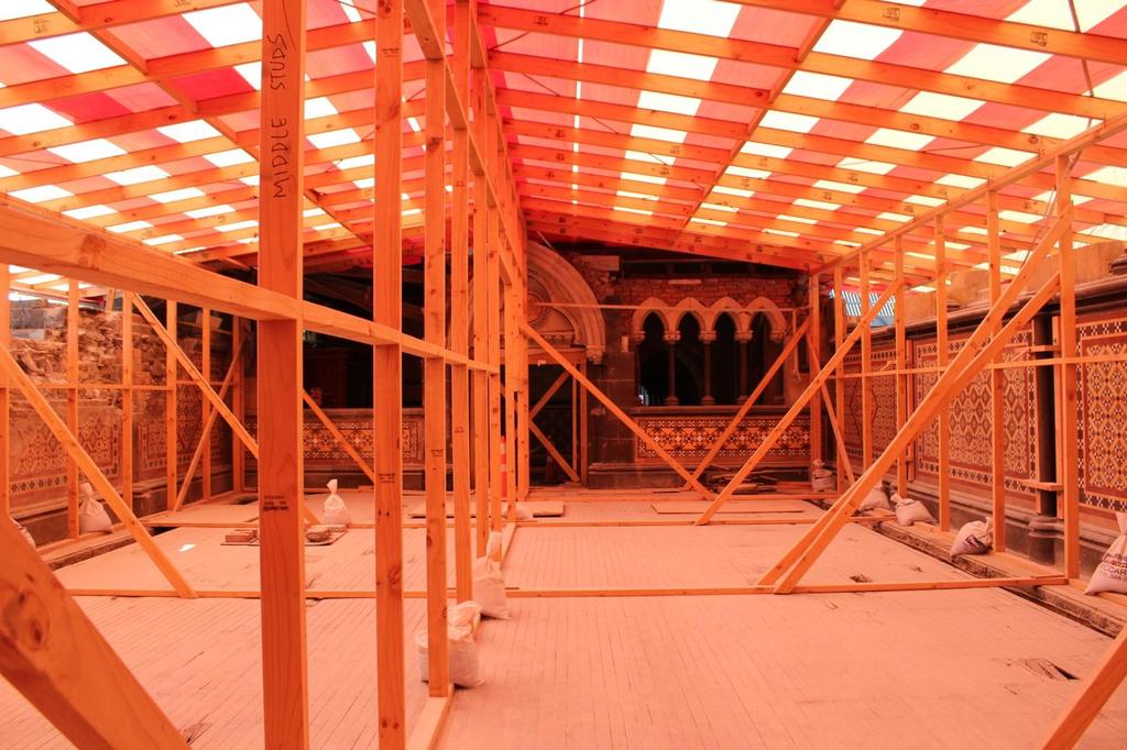 1865 stone chamber bathed in orange light from the temporary plastic roofing membrane.