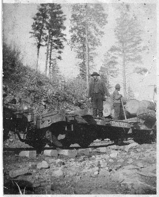 RD079-003 Author Station/Site Flat 3/4 view of a D&RG flat car equipped for hauling logs with two workers loading logs.