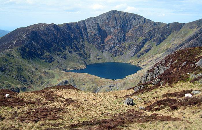 Armchair shaped hollow in the mountainside Steep back wall Tarn Rock lip at the front