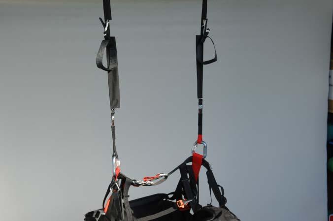 The risers, labeled L and R attach to the corresponding (left and right) carabiner or to the dedicated reserve bridle attachment points on the shoulder of the harness. Fig.