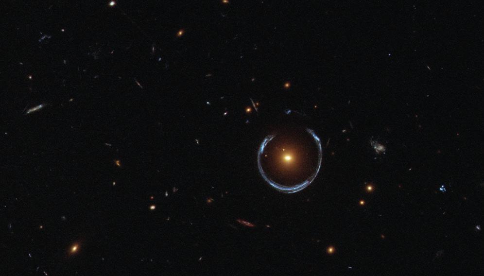 Gravitacijska sočiva Na ovoj slici koju je snimio Svemirski teleskop Habl plava galaksija u daljini jako je izobličena delovanjem mase bliže galaksije u prednjem planu.