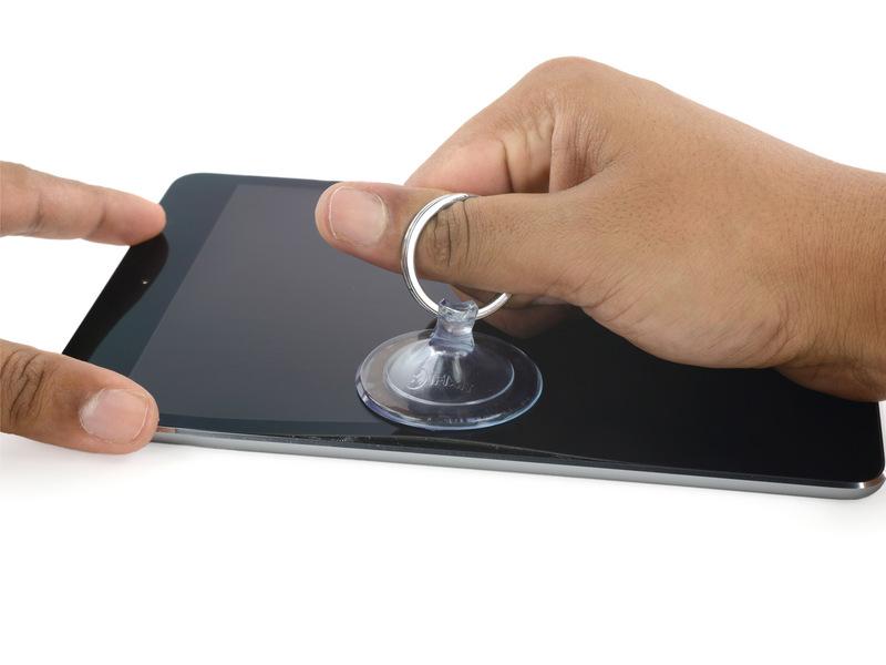 While holding the ipad down with one hand, pull up on the suction cup to slightly separate the front panel
