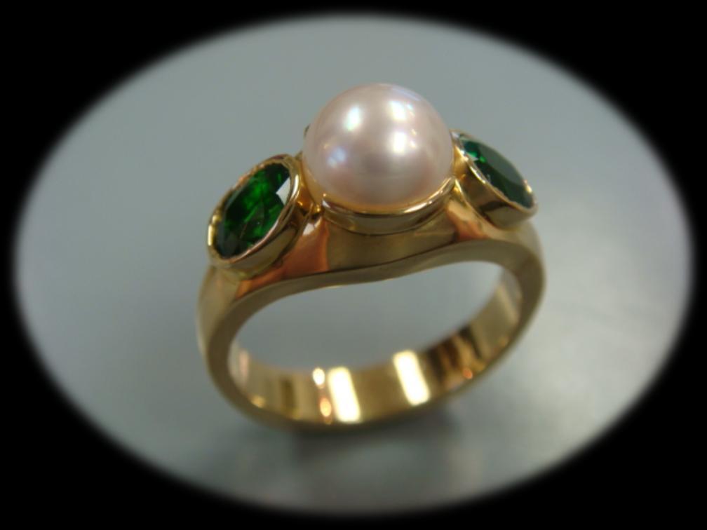 Ladies Day Ladies, treat yourself to this beautiful18k yellow gold designer ring featuring a single seven millimeter Japanese Akoya cultured pearl and two oval genuine chrome green tourmaline gems