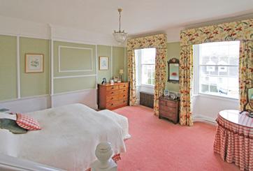 The dining room and sitting room are at the south end of the house with tall sash windows overlooking the front.