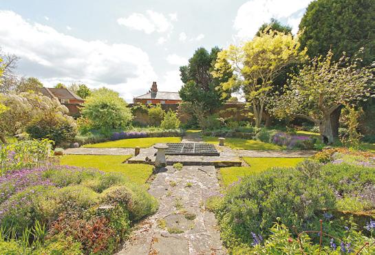 It is mostly laid to lawn with beautifully tended flower beds, mature shrubs and trees.