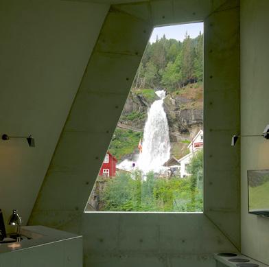 The two building sections extend from the wall, twisting and turning towards the waterfall.