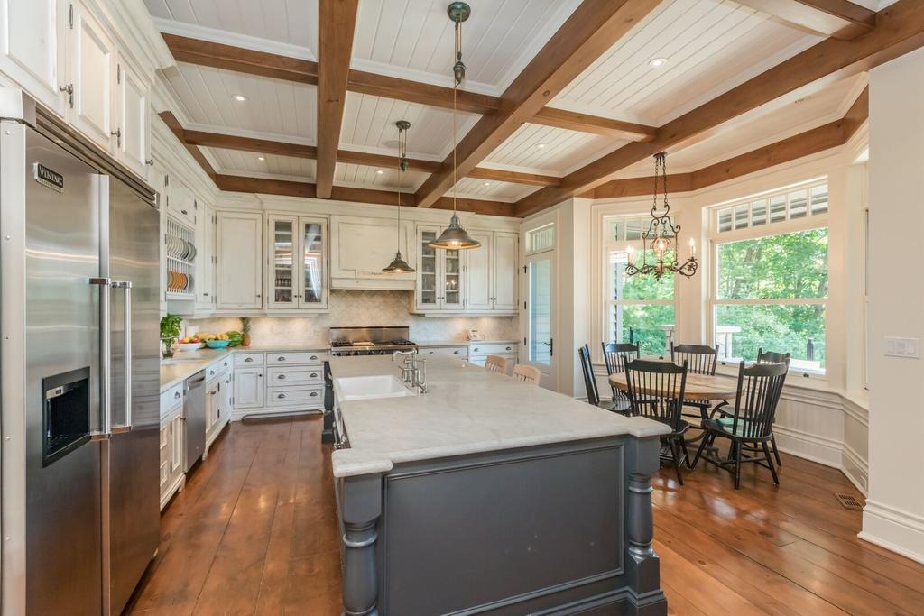 breakfast feeding, Carrara marble counters, custom cabinetry, Wolf range, and a full suite of stainless steel appliances plus a walk out to the outdoor screened dining deck From the left of the foyer