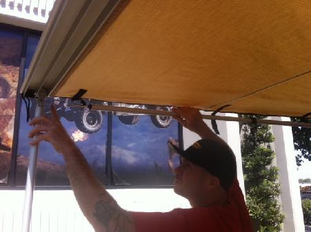 Slide the pin on the end into the hole on the awning.