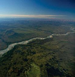 The boundary between the Cordilleran Central Mackenzie Plain LSb Ecoregion and the Taiga Plains North Mackenzie Plain LS Ecoregion is on the far side of the river, where many small ponds characterize