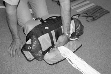 Lay the parachute back down and redress in preparation for inserting it into the free bag. Remove all packing paddles.