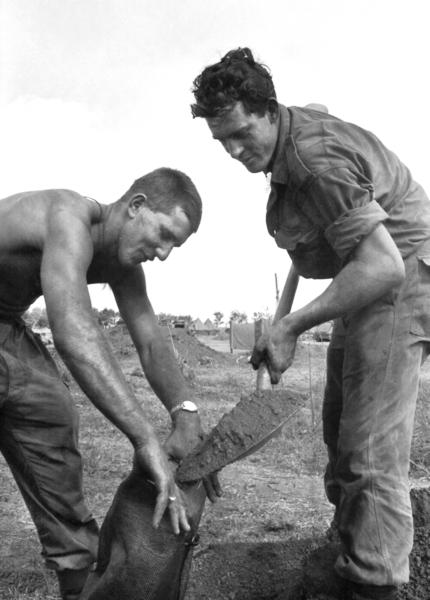 In Bien Hoa Province in February 1968 Sappers Brian Hopkins (left) and Vic Underwood are hastily filling sandbags to ensure their protection against possible Viet Cong attacks during Operation Coburg.