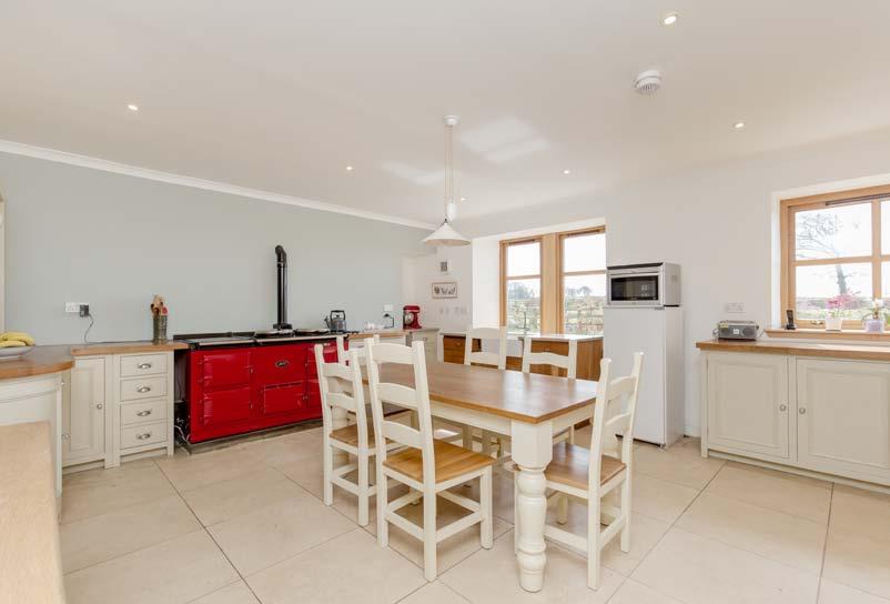 The beautiful farmhouse breakfasting kitchen has a four oven Aga, Neptune kitchen cabinets and a free standing dresser, Belfast sink set in a Silestone worktop, integrated dishwasher and Travertine