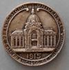 Lot # 119 - Medal "Republic Argentina" picturing shaking hands inside a wreath with the sun and rays at the top. On the reverse is the Argentina Pavilion in the center with "1915" below.