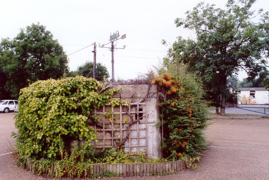 Here the pillbox has been retained at the centre of the car park of a garden centre and café, and plants have been grown against it.