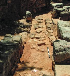 The southwest wall of the room had a very unusual construction in that thin slab-stones were set upright along the lower part of the wall and then covered with clay lining (Fig. 12).