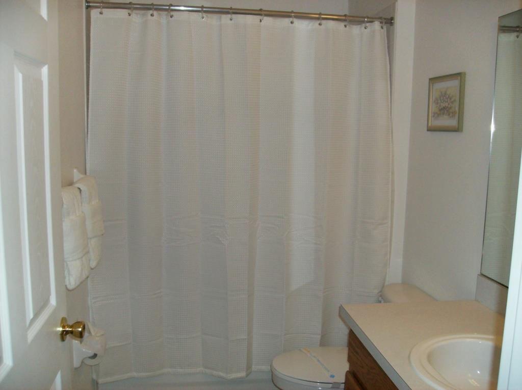 Our guest bathroom consists of bath with overhead shower, toilet and Hollywood style mirror.