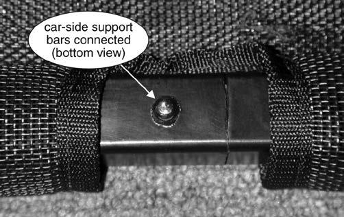 Slide both of the support tubes through the center of the Tow Defender and into the sleeve at the edge of the screen (Figure 7), so that the hole and the push-button lock are at the center.