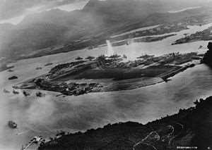 Japanese aeroplanes attacking Battleship Row. As seen from the southwest. Ford Island is in the centre of the picture, and Battleship Row is behind the island.