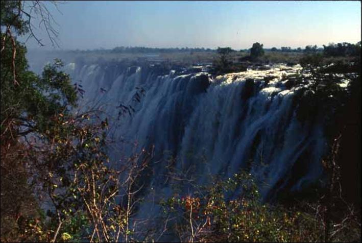 Victoria Falls The falls average over 300 feet (100 m) in height and stretch over one mile (1,688 m) from the Zambian side to the Zimbabwe side,