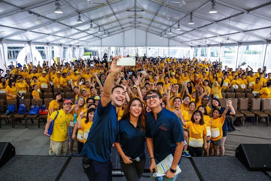 Emcees Paul Foster, Charmaine Yee and Glenn Ong gathering the crowd for a WeFie at Play It Forward 2016 Up from 25 participating teams and 15
