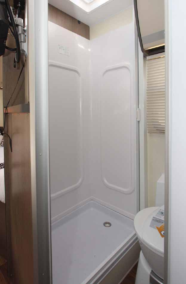 Bathroom houses toilet and separate shower cubicle.