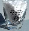 Lot # 256 - Shot Glass picturing the "Heliport" with the Unisphere logo on the other side with "New York World's Fair 1964-1965" above the logo. The printing is black.