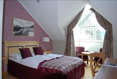 They have one queen sized bed and a bay window with view towards the fjord. They also have bathroom with bathtub.