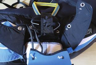 Open the reserve parachute container on the rear of the harness by opening the zips.