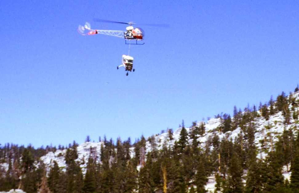 A 1971 photo by Jeff Yohe of a Bell 47 helicopter removing the wreckage of what appears to be a Cessna from