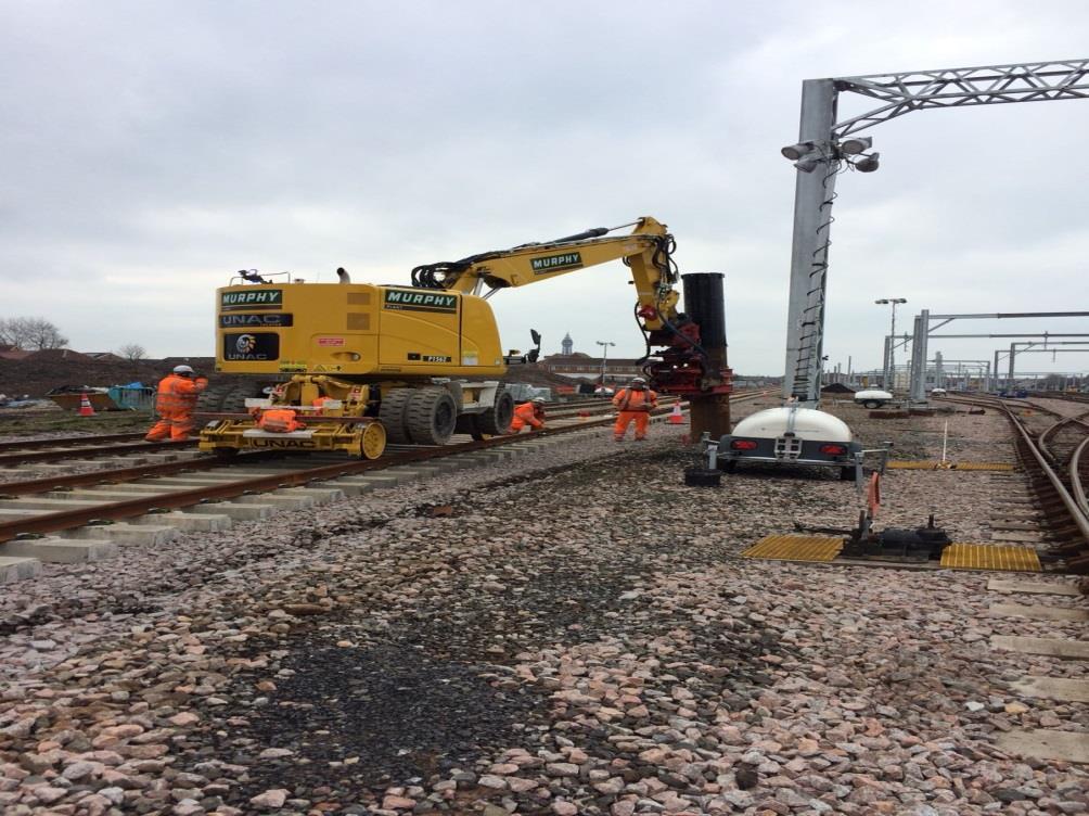 Orange install overhead line equipment foundations on the station approach.