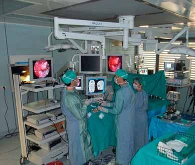 Medicina Slika 2. Prikaz v operacijski dvorani. Vidi se postavitev bolnika, obeh kirurgov ter ostalega osebja, obeh monitorjev za endoskopijo ter monitorja za nevronavigacijo.