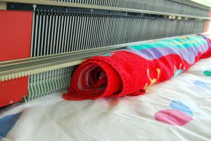 Roll up a large bath towel and place it behind the machine to