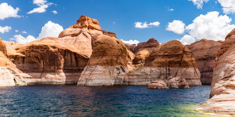 Horseback riding is another popular way to see the highlights of the park. Stop at Lake Powell, a body of deep blue water surrounded by -red cliff walls.